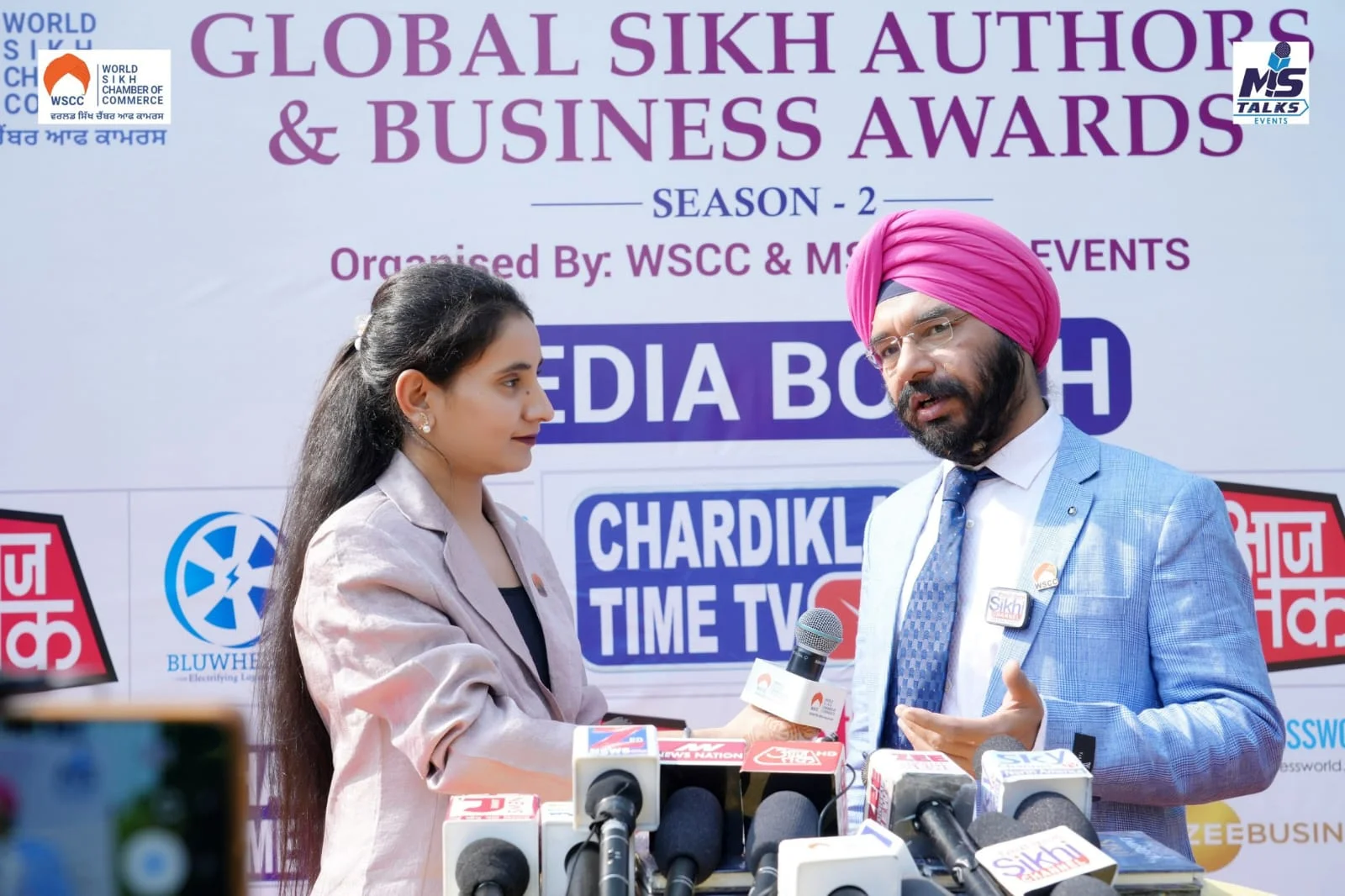 Female journalist interviewing Dr. Bhupinder Singh Arora at an event