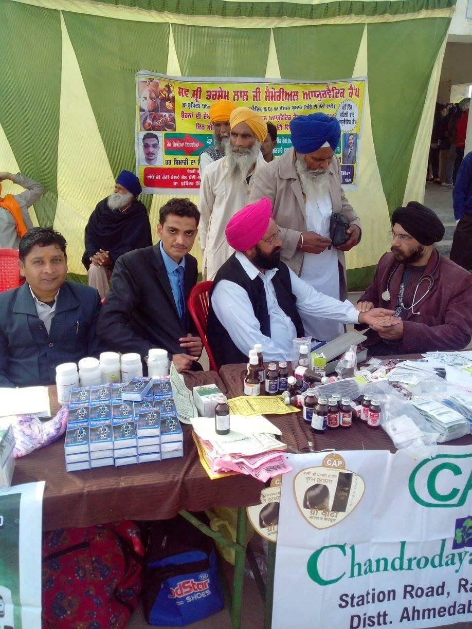 Dr. Bhupinder Arora examining a patient during a health camp