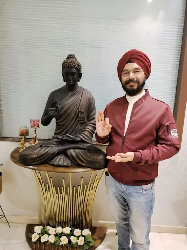 Dr. Bhupinder Arora posing with the Lord Buddha statue