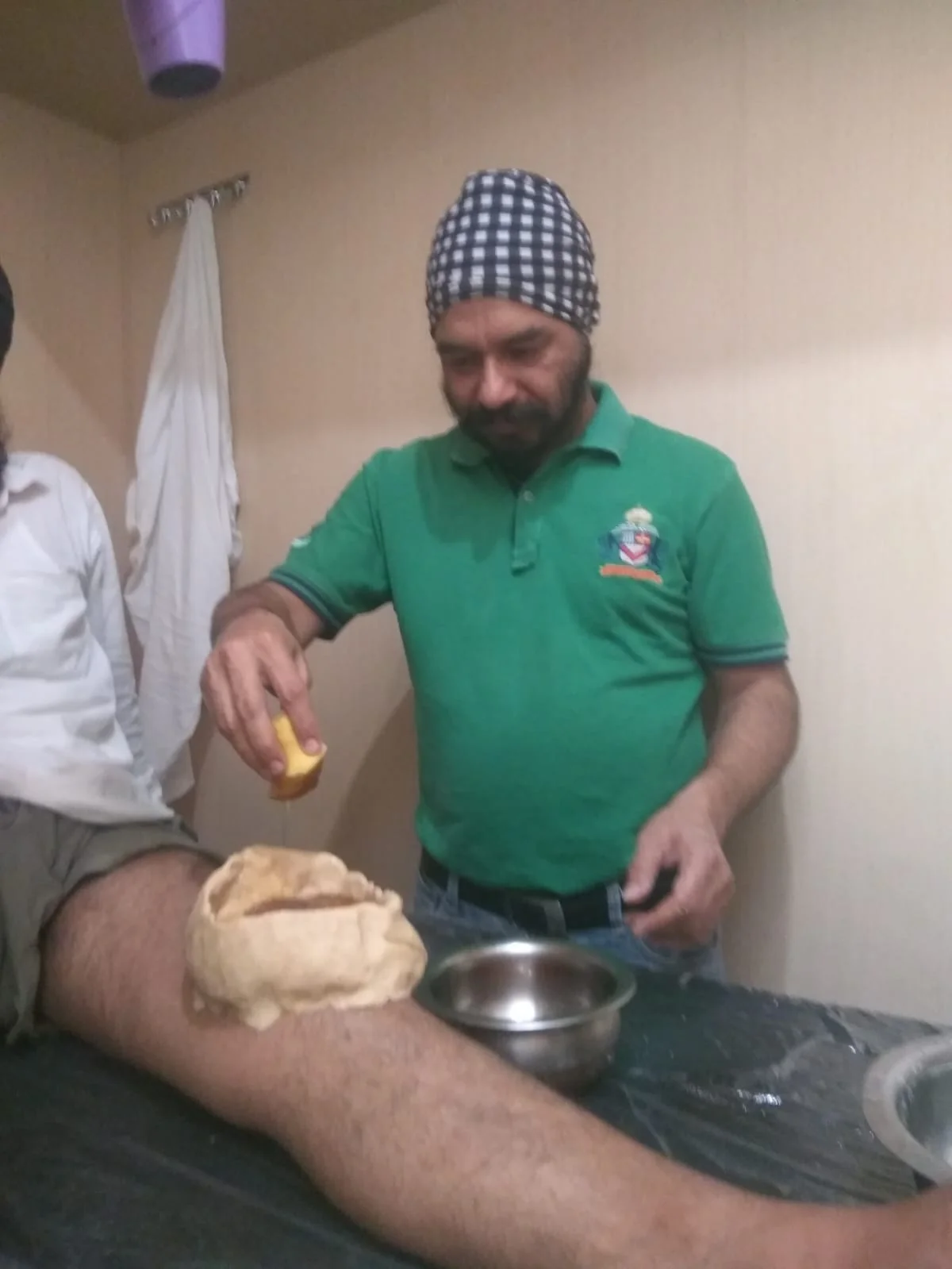 Dr. Bhupinder Arora performing Janu Basti therapy on a patient's knees