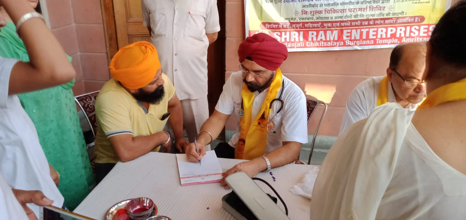 Dr. Bhupinder Arora explaining medical treatments to patients at a free consultation camp