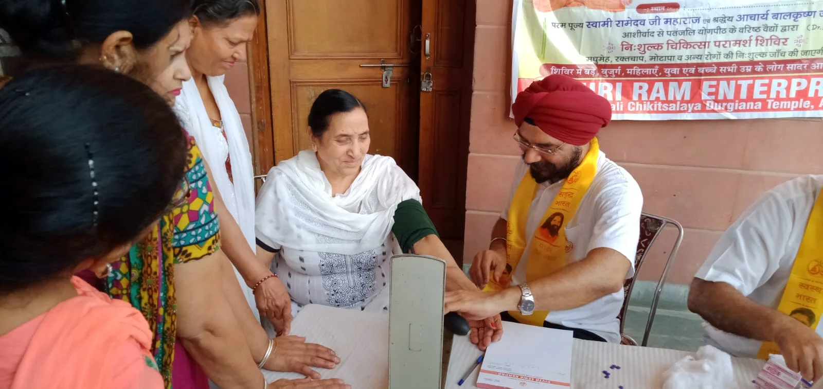 Dr. Bhupinder Arora performing a free medical examination at a public camp